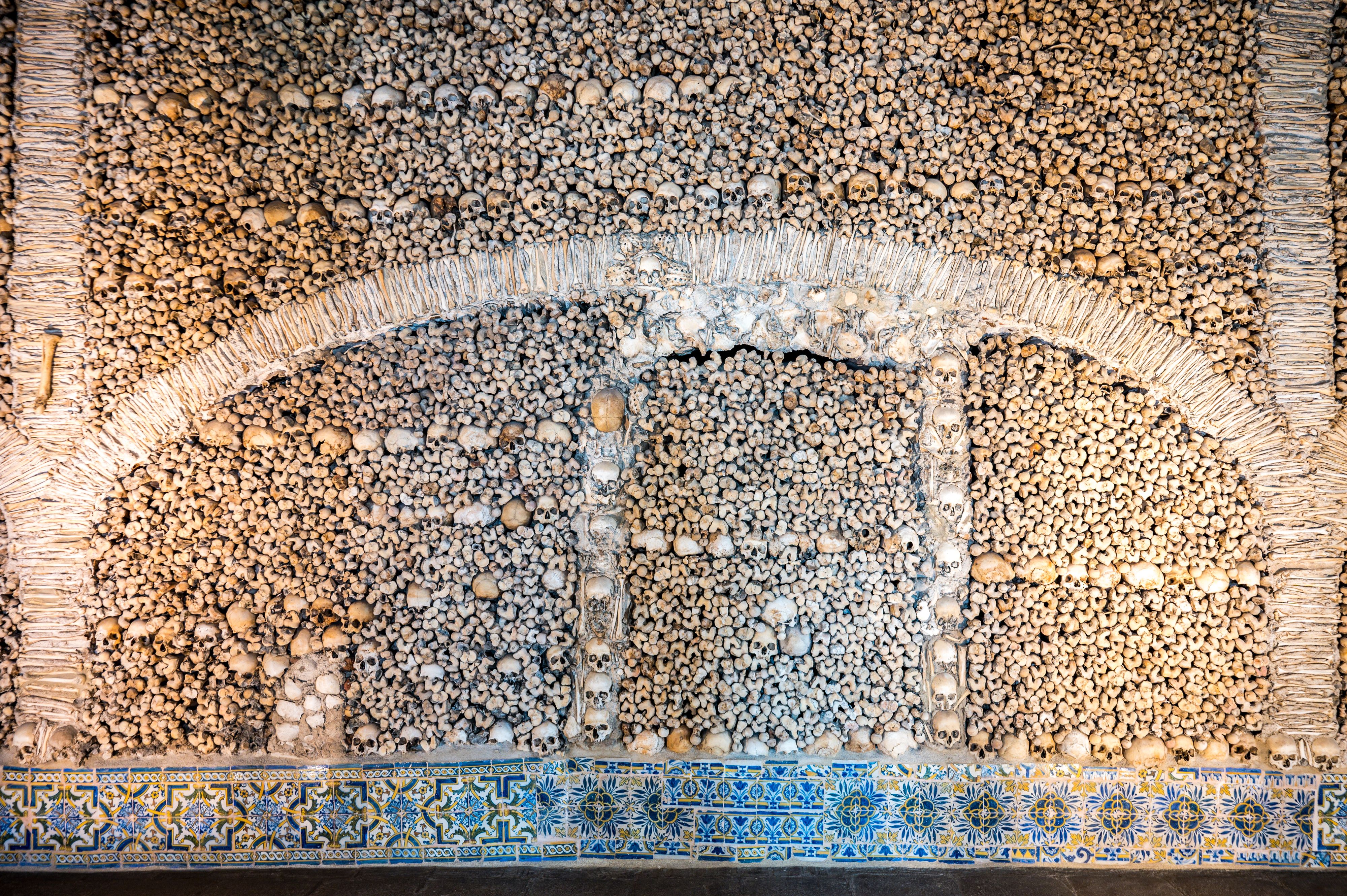 Skulls bones and blue tiles in Portugal catacombs