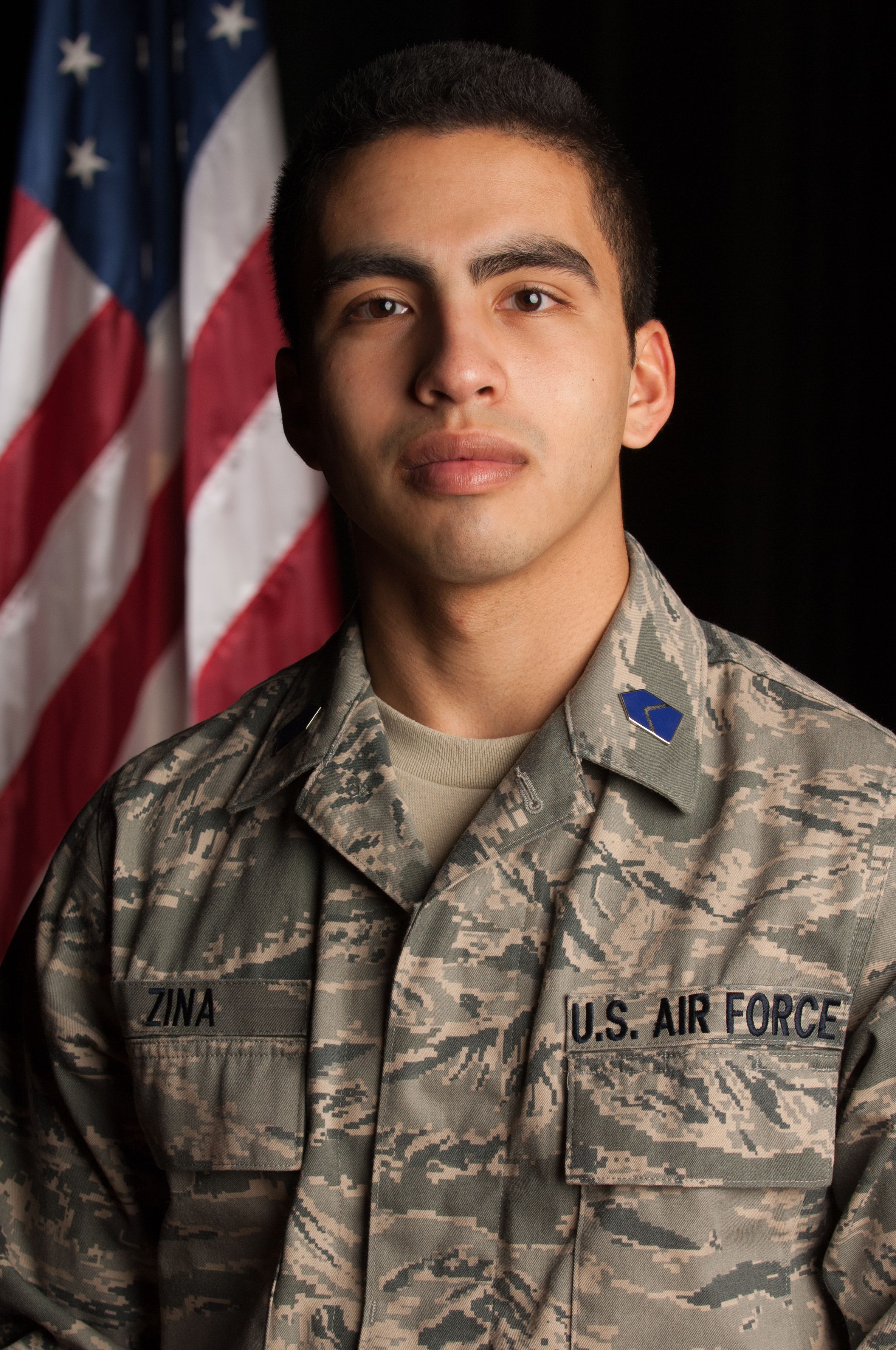 Studio portrait of ROTC man with American flag on black background