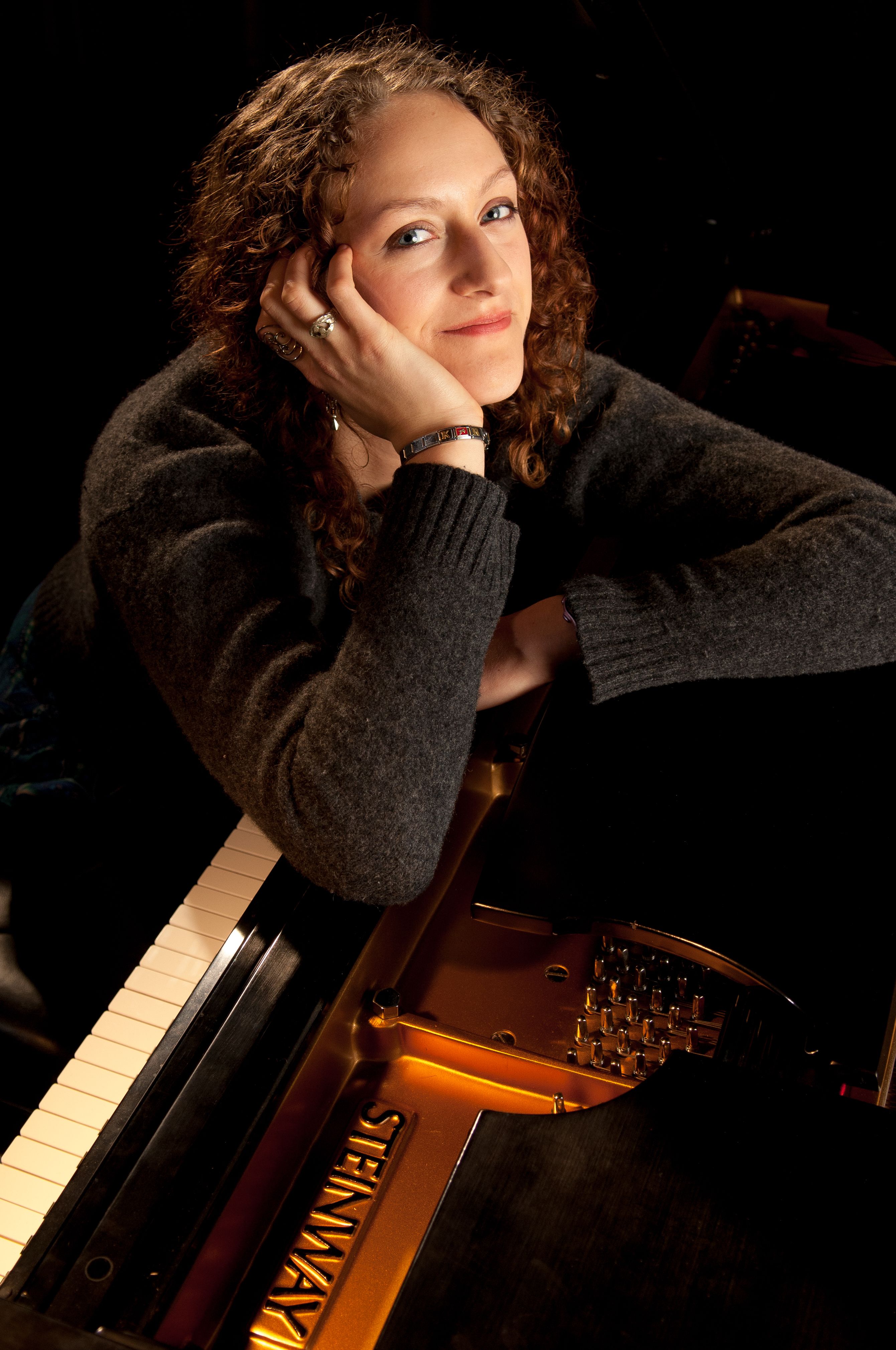 Portrait of young female pianist with Steinway piano