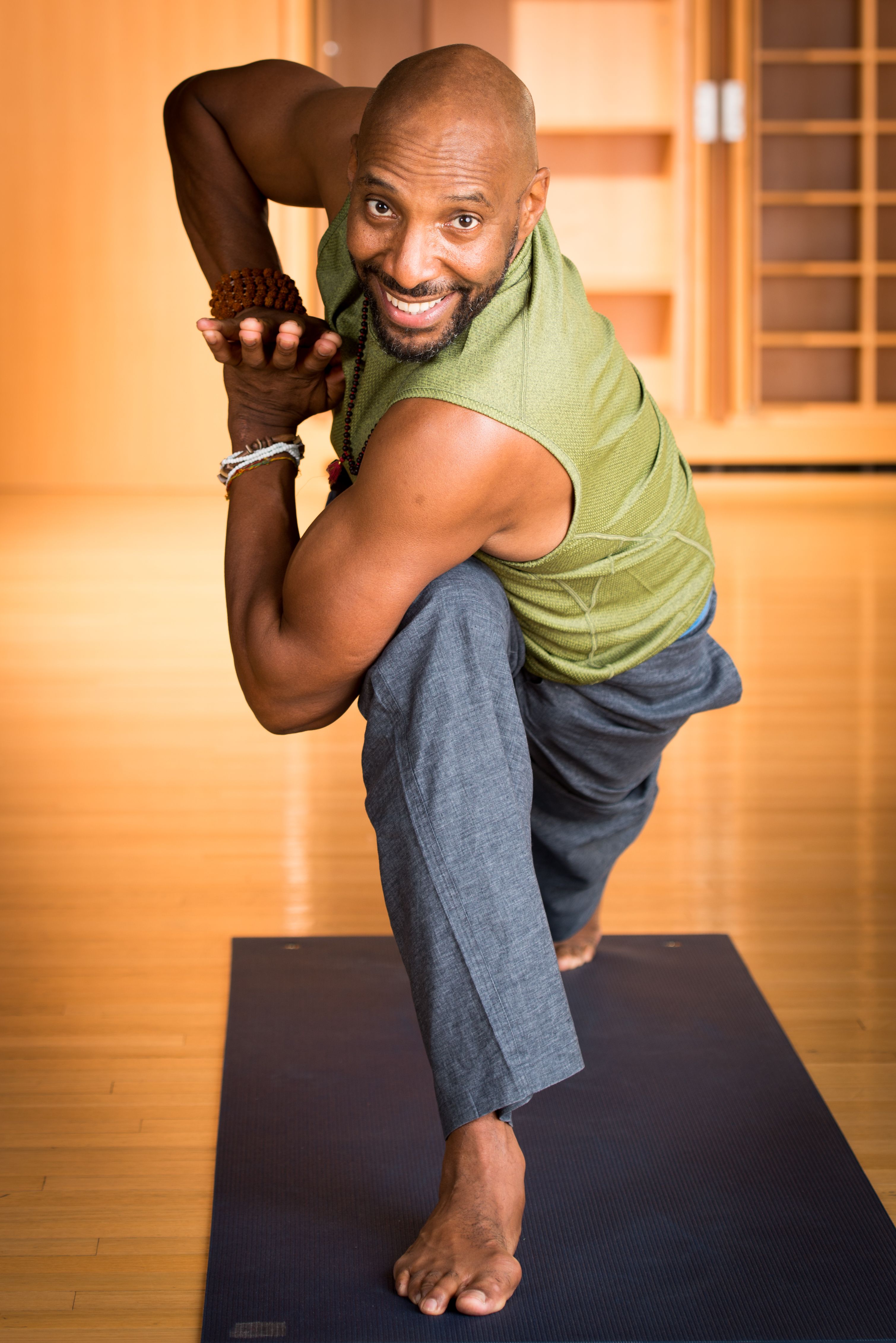 African American man in yoga pose in warm wood room