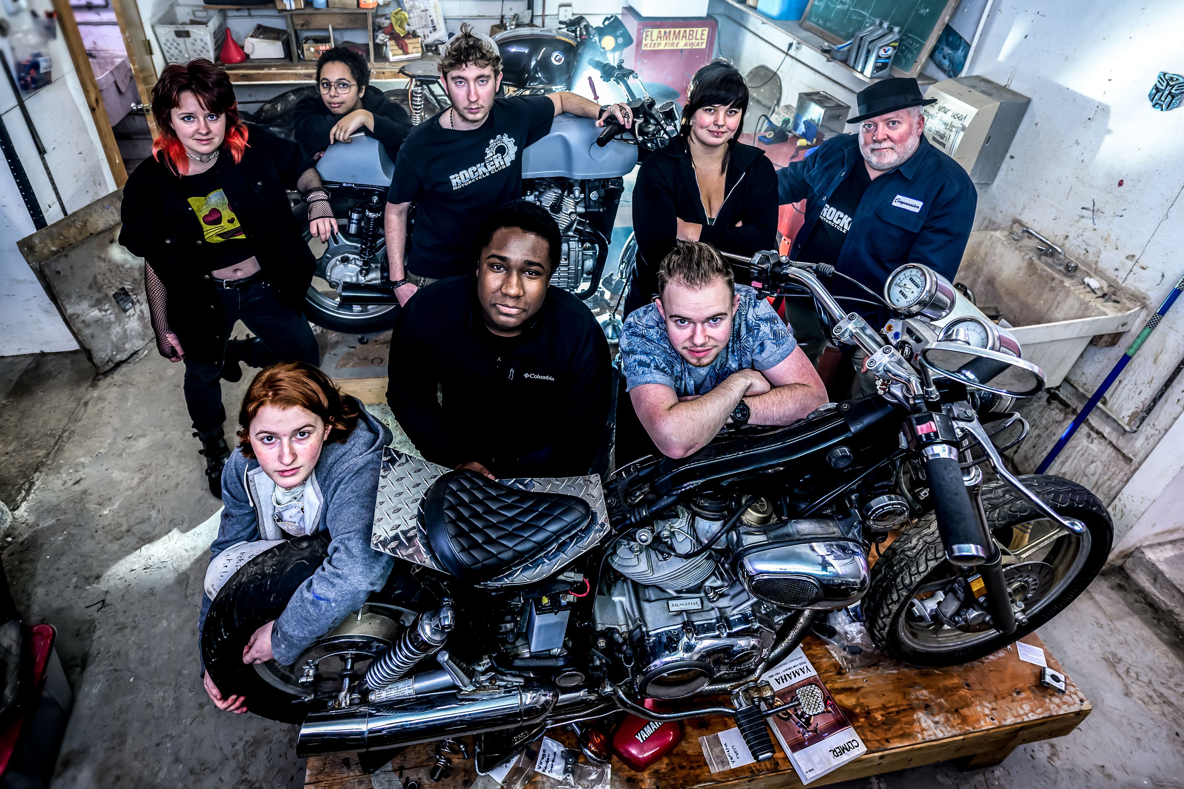 Group of students with motorcycle in shop