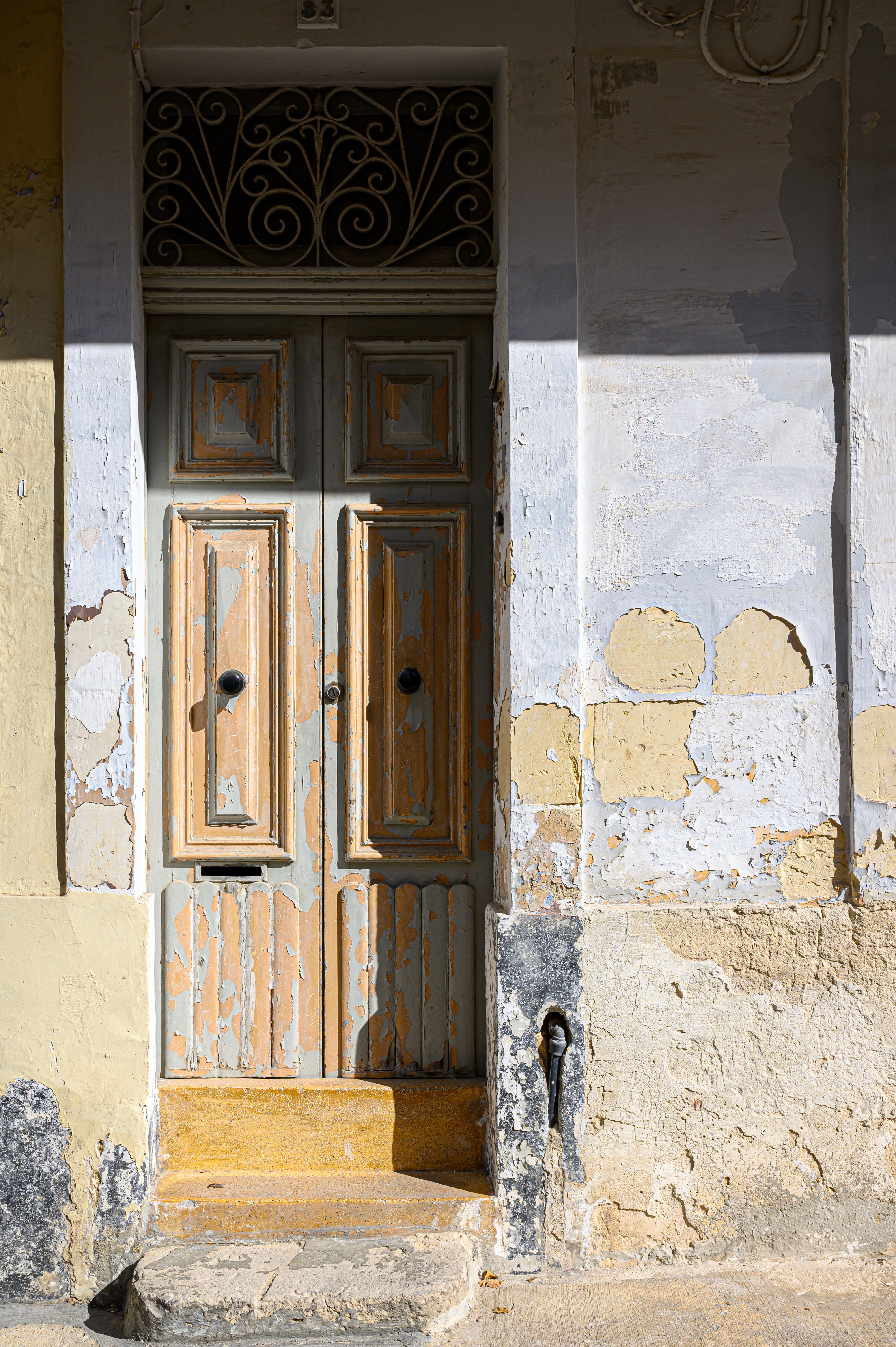 Weathered doorway painted yellow and blue in Malta