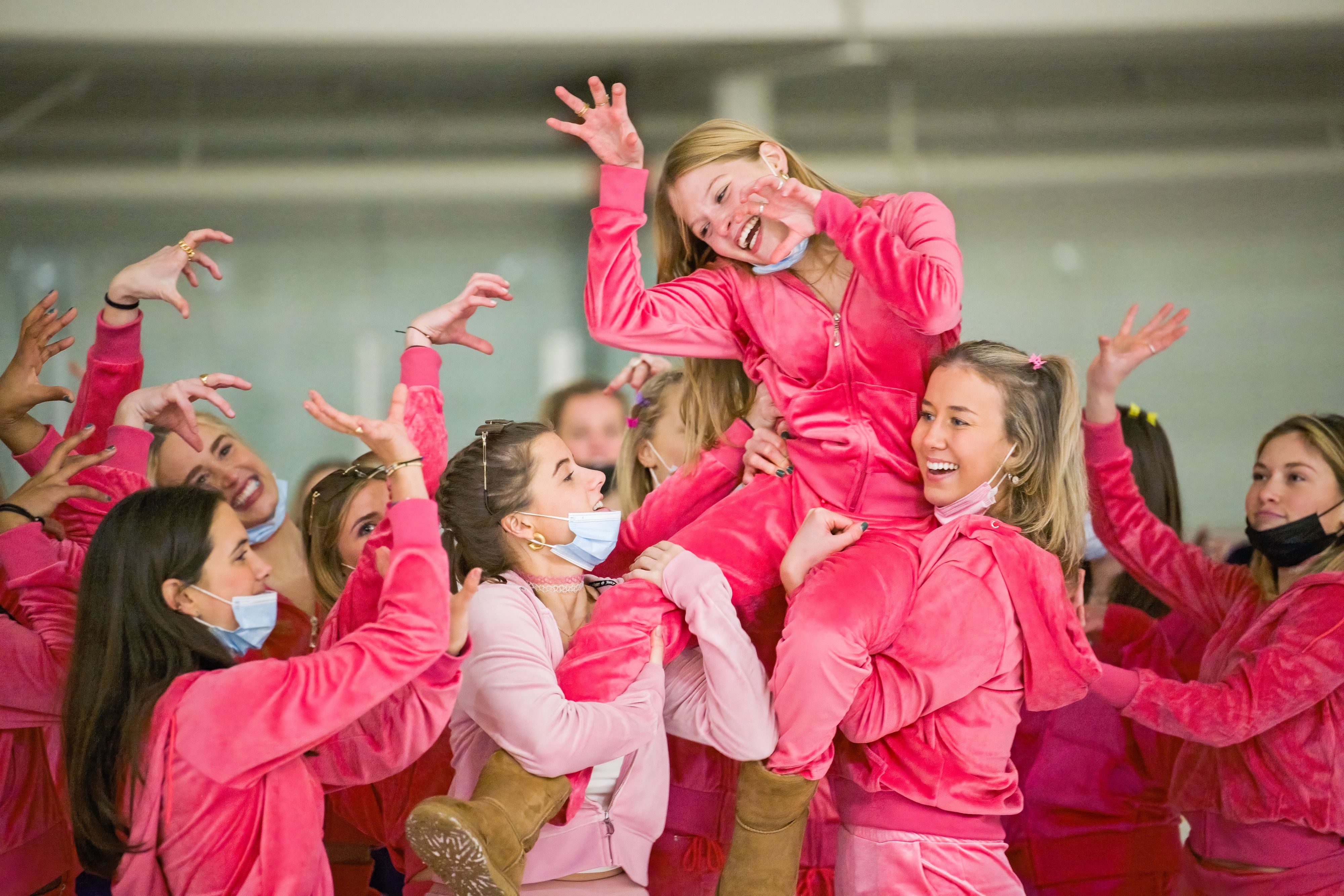 High school girls wearing pink performing with hands up 