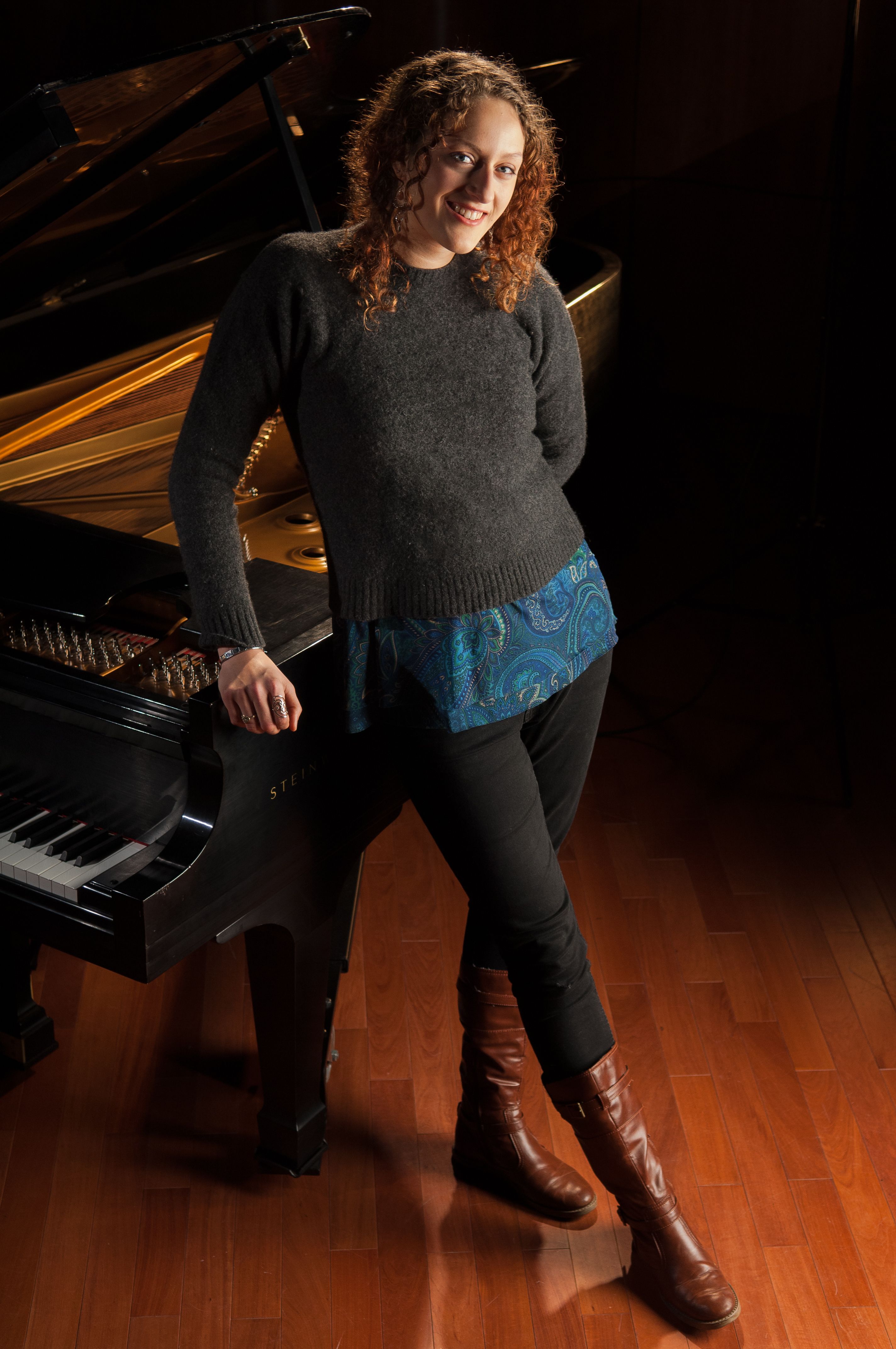 Portrait of young pianist standing with her piano