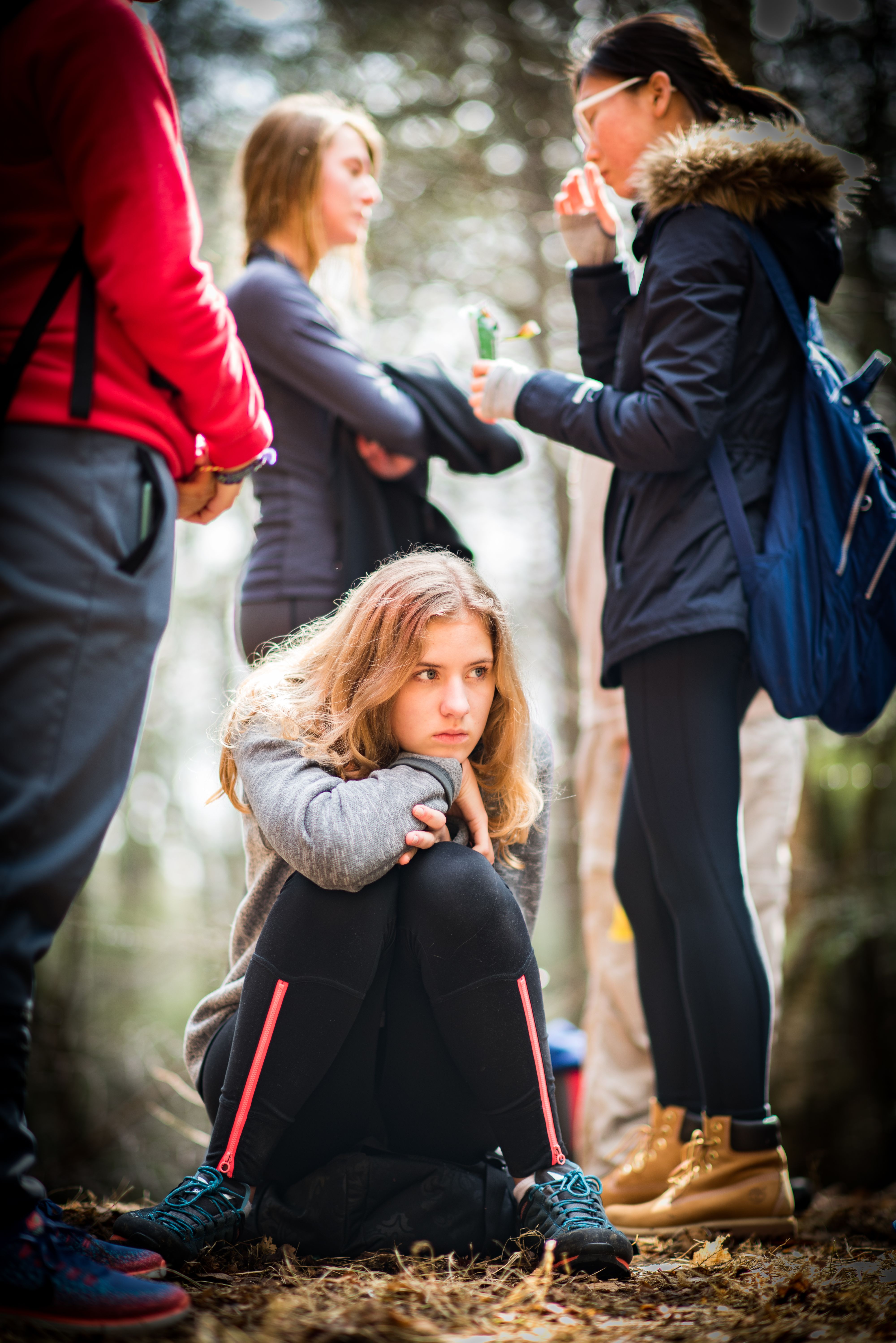 High school girl sits for a quiet moment on a hike with her classmates
