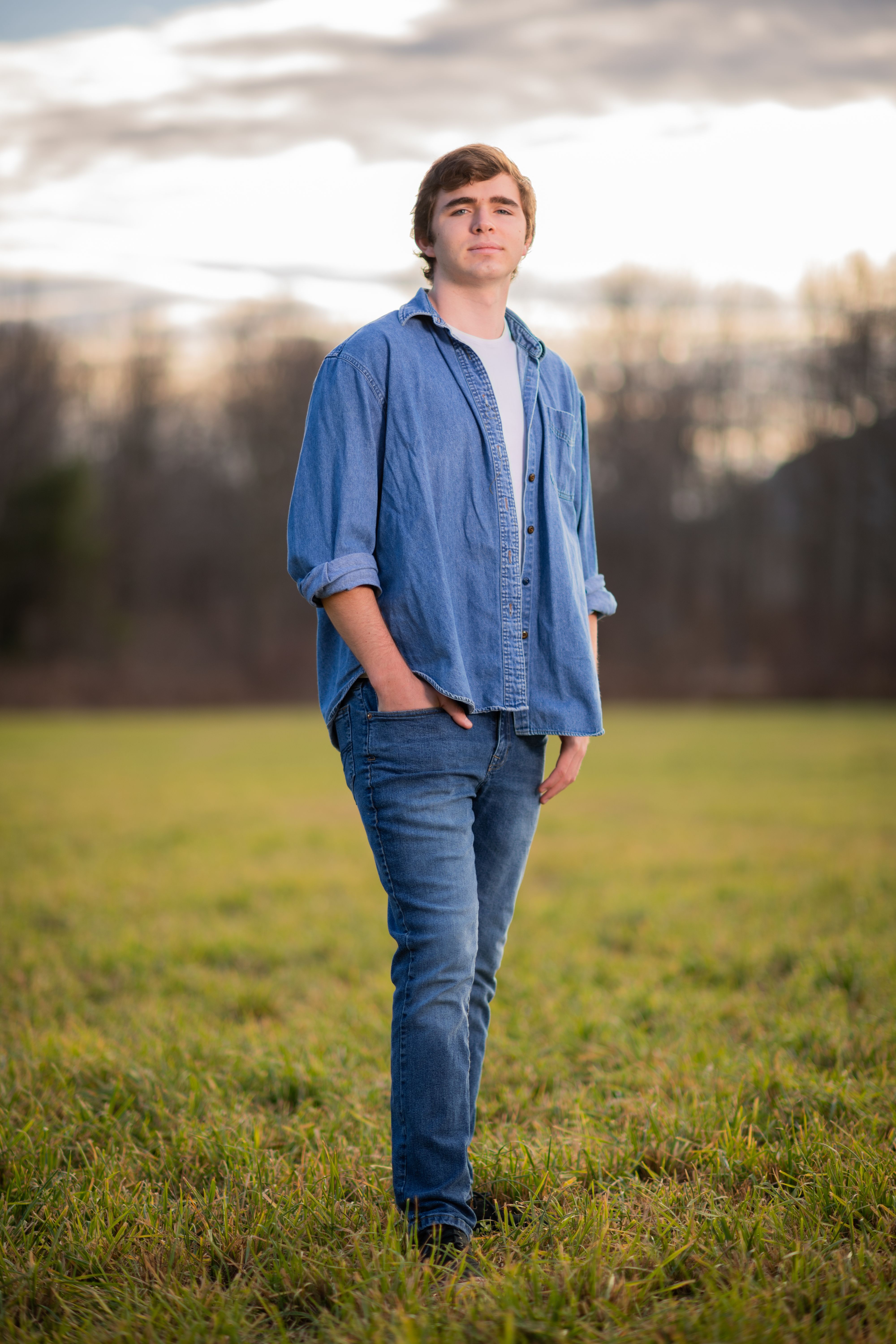 Young man stands in field for portrait