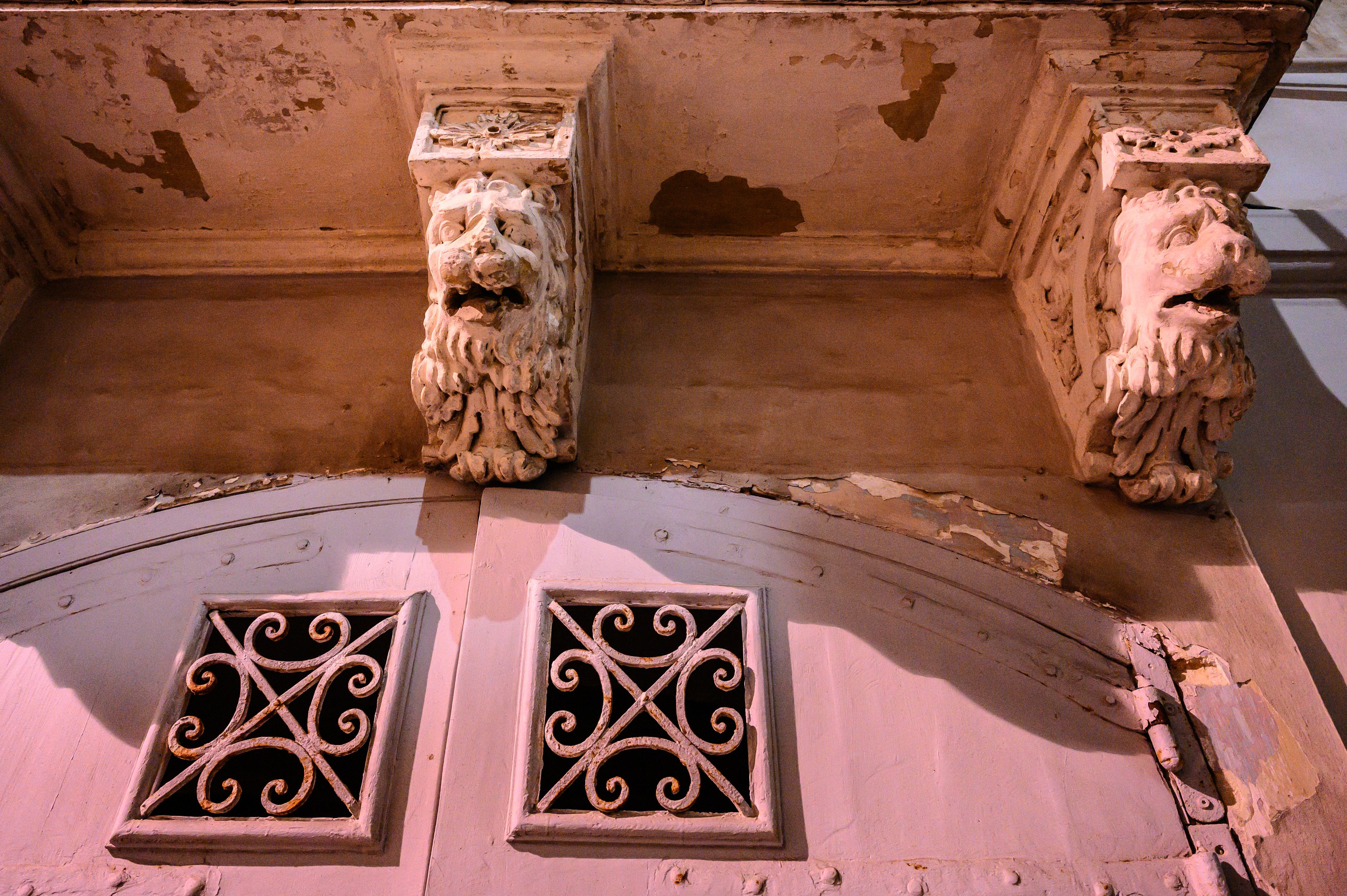Detail shot of pink painted Malta building with lions