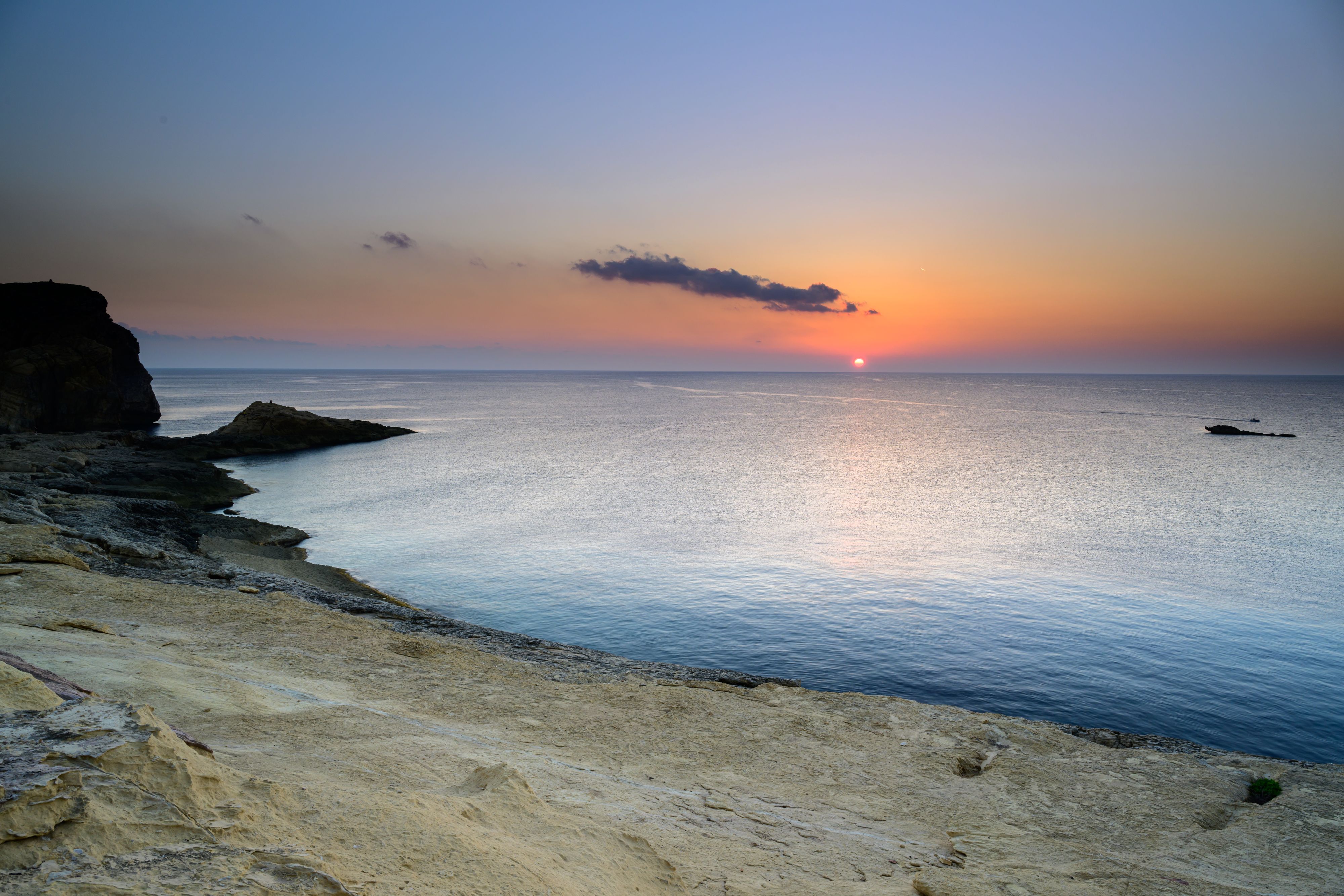 Sunset at rocky shoreline in Malta