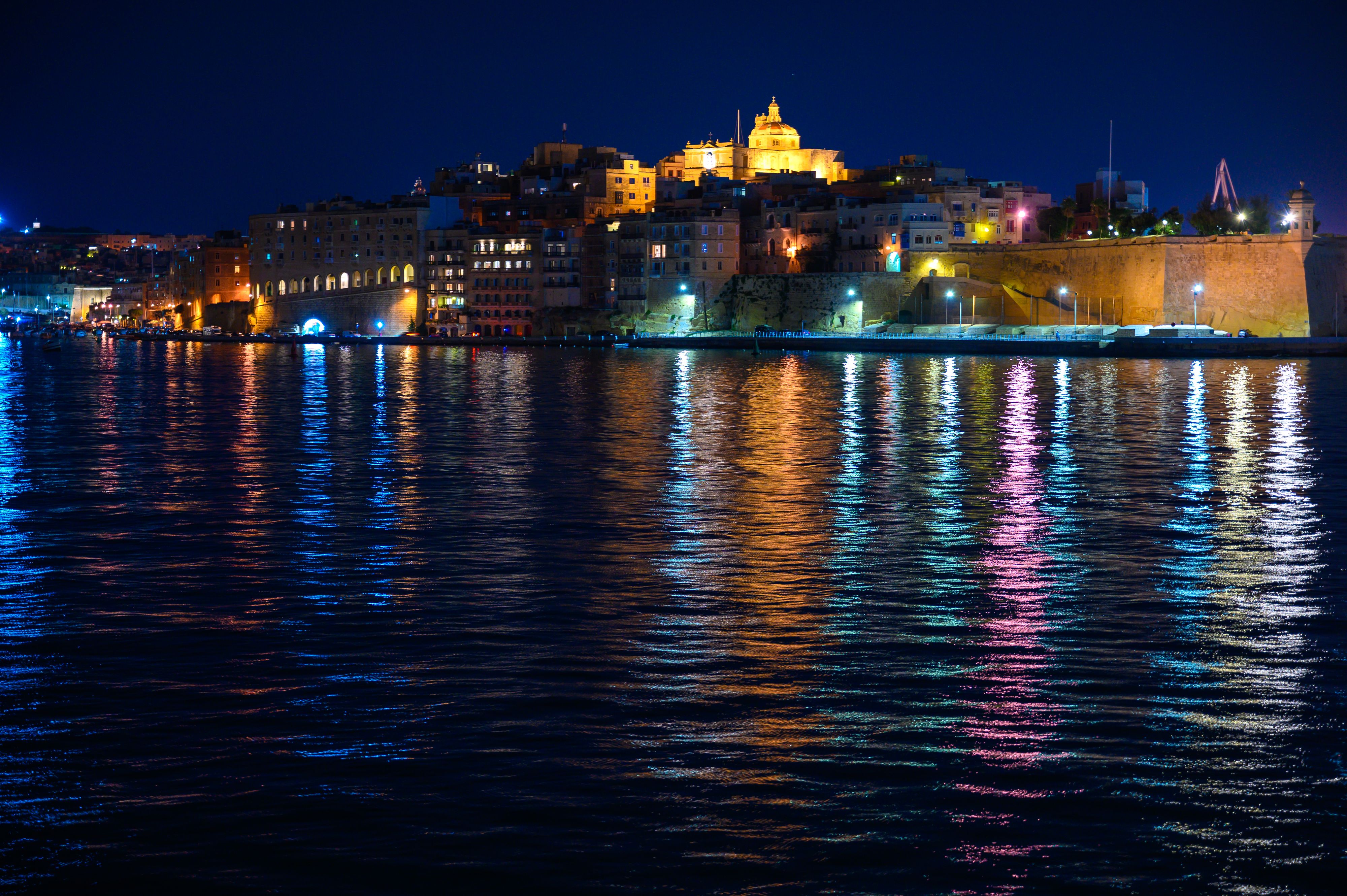 Night looking at buildings reflecting in water in Malta