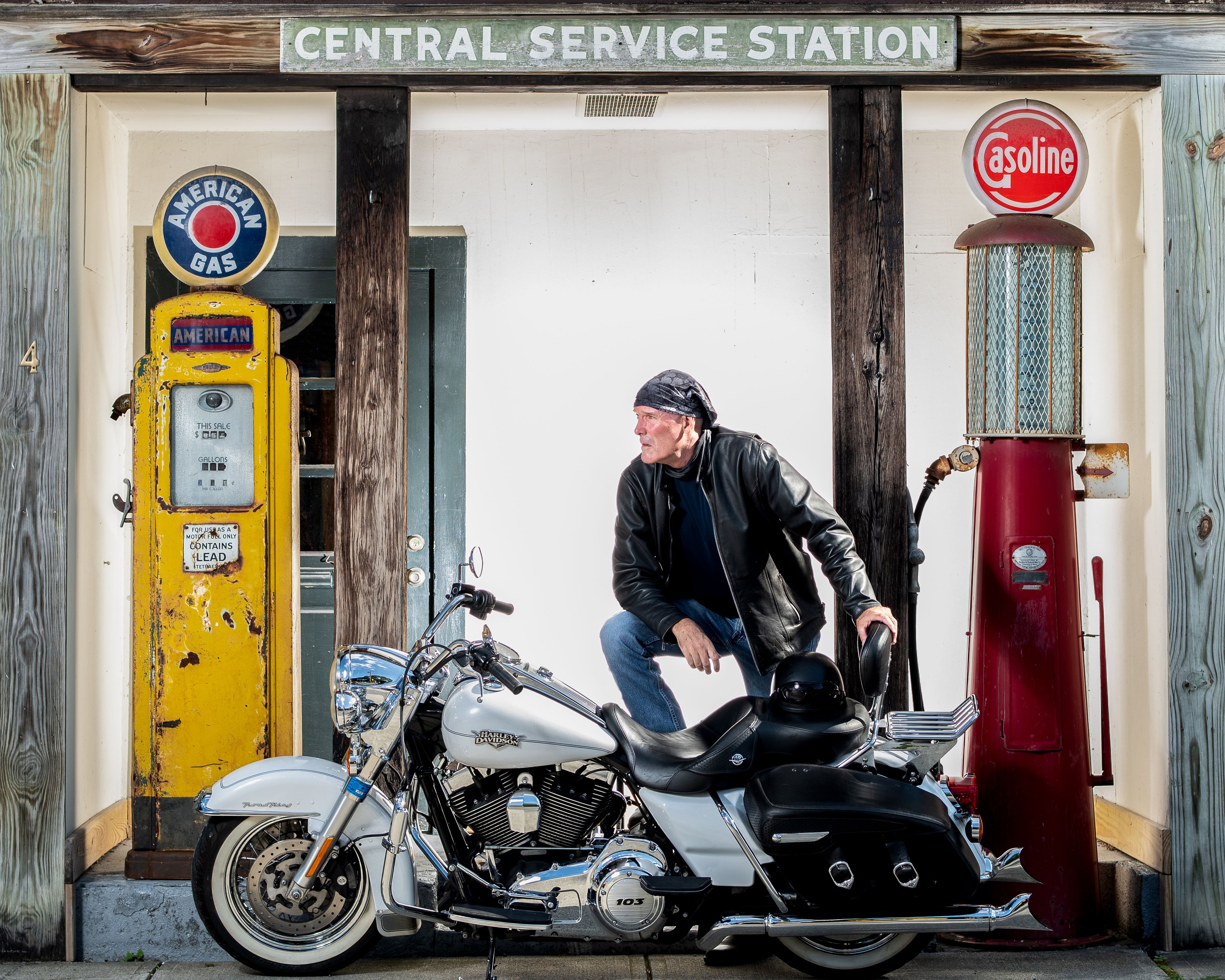 Man with Harley Davidson at old service station