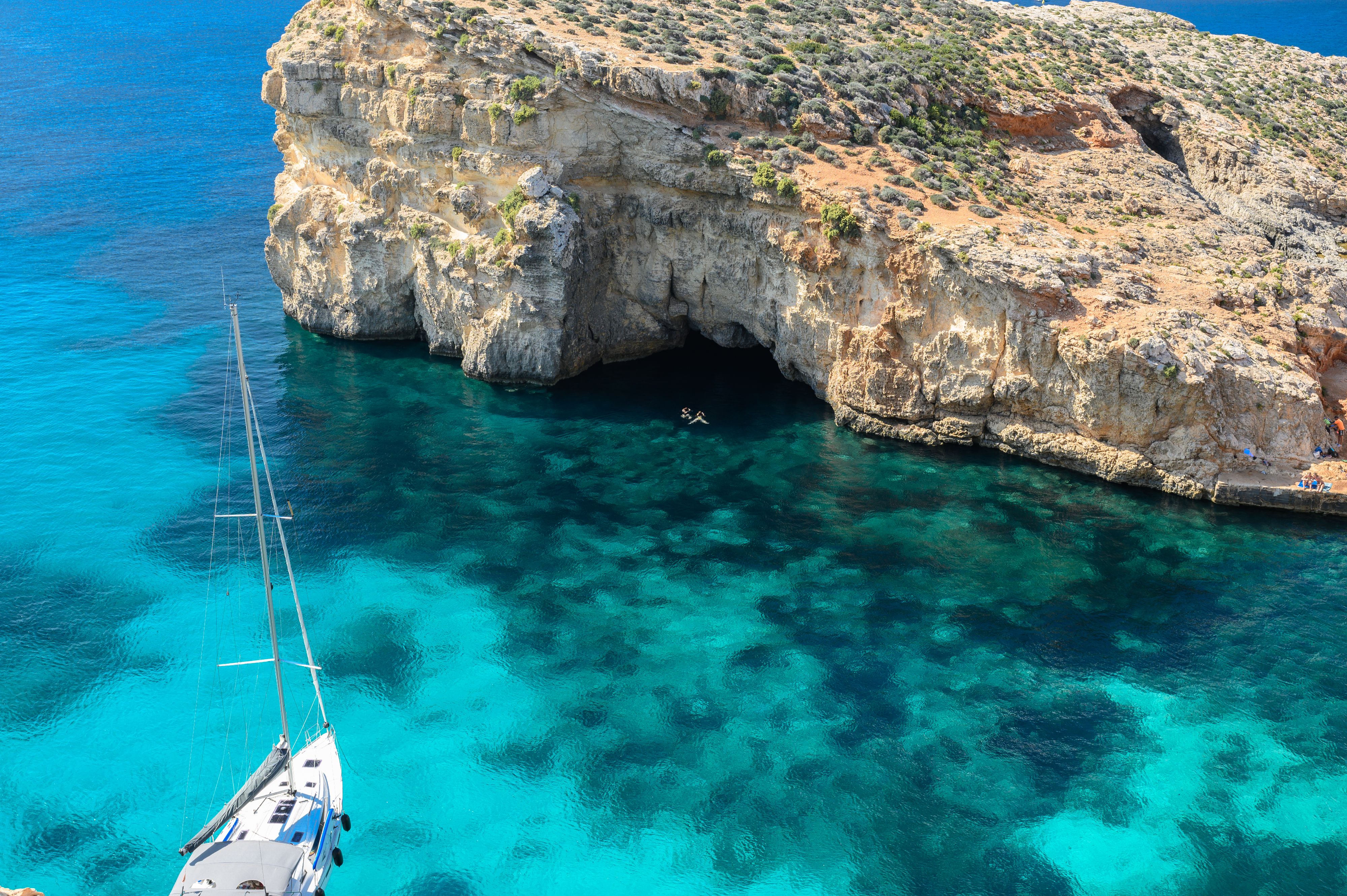 Blue Lagoon in Comino Malta with sailboat and swimmers