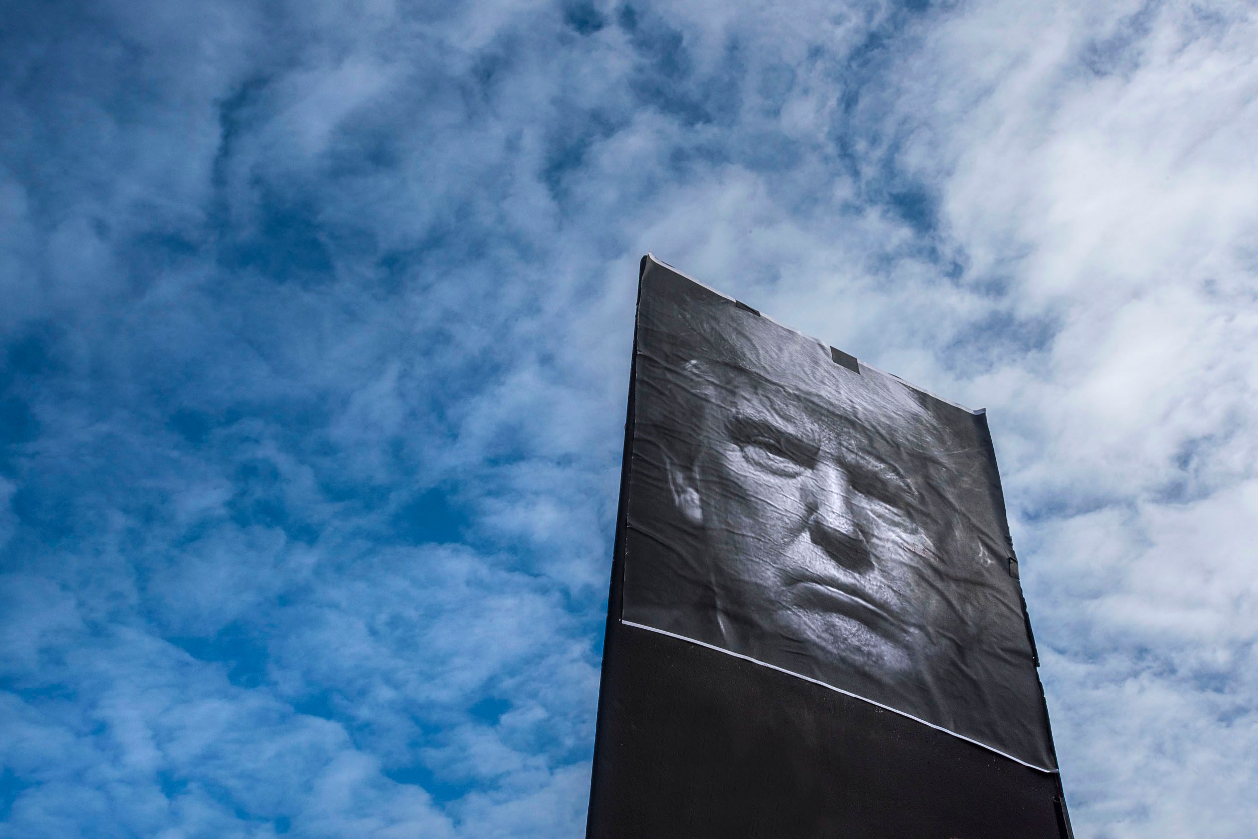 Photo of Donald Trump against white clouds.