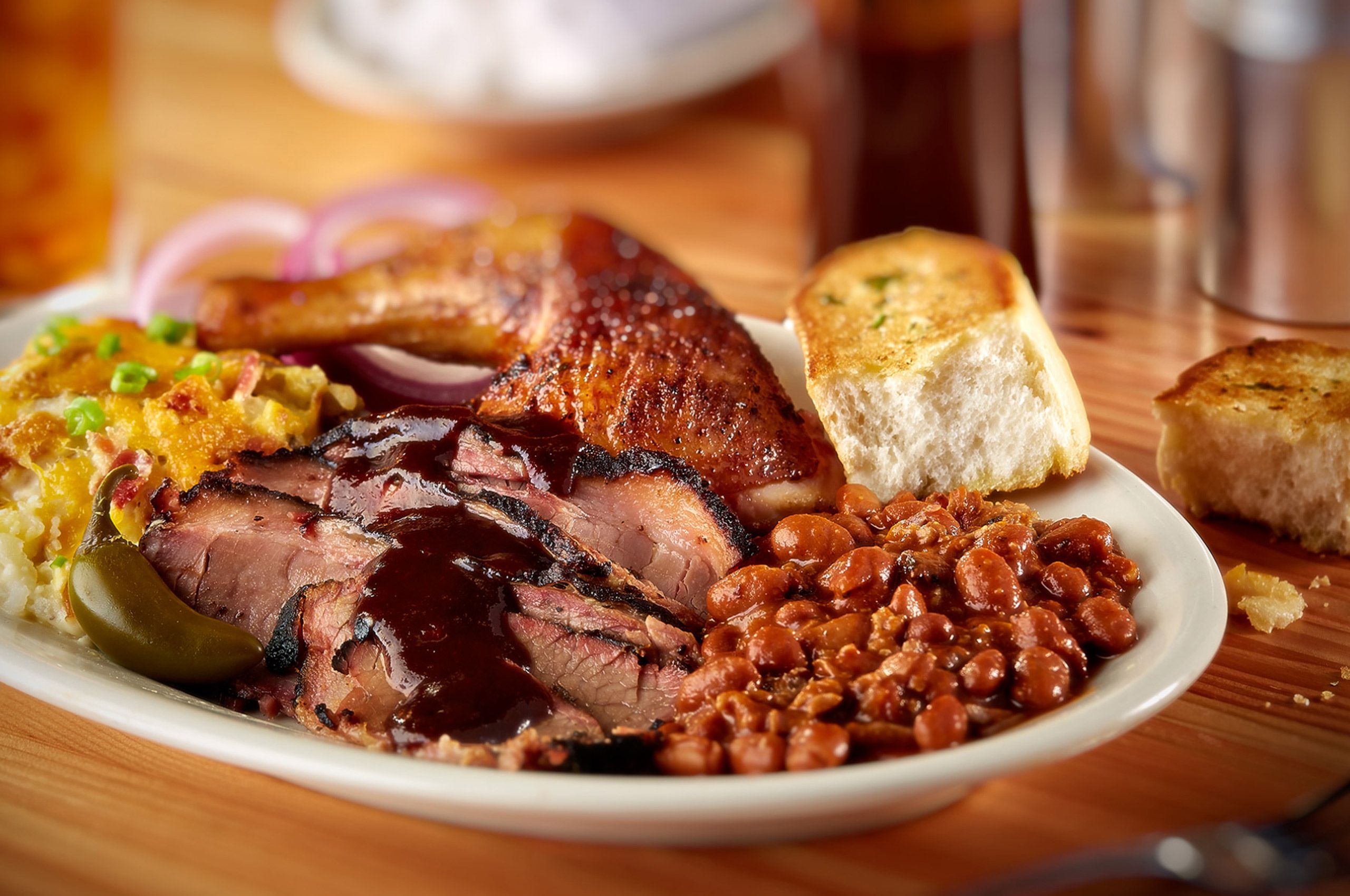 Bone Daddy's barbecue plate with sauced brisket, smoked chicken, baked beans, and Texas toast in Dallas, Texas