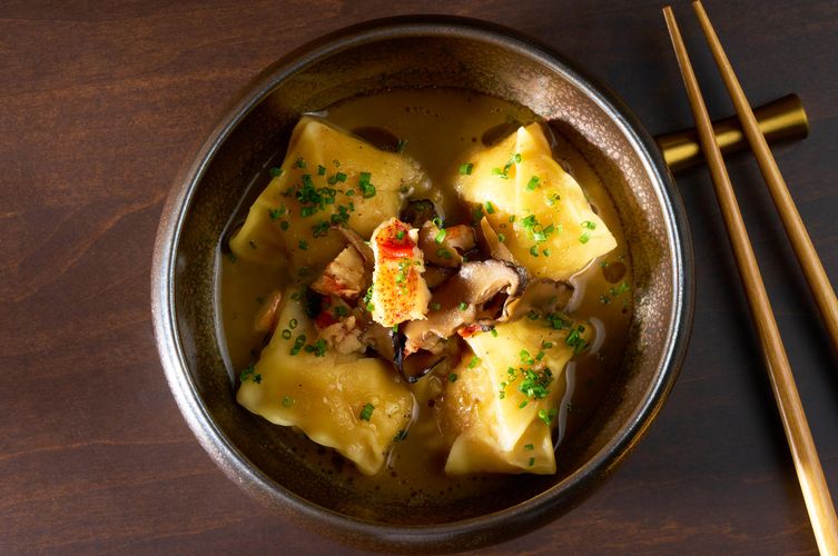 Overhead of dumplings in broth with lobster and shiitake mushrooms in a brass bowl at Soy Cowboy in Arlington, by a commercial food and interiors photographer