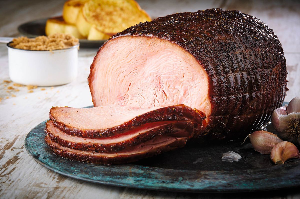 Ranch House mesquite smoked peppered ham sliced on a dark patinated platter with garlic and brown sugar