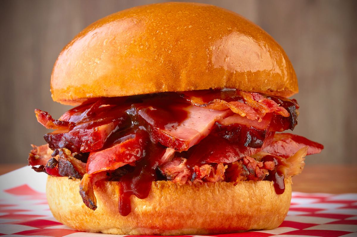 Bone Daddy's barbecue sandwich piled with sauced smoked meat on a toasted brioche bun
