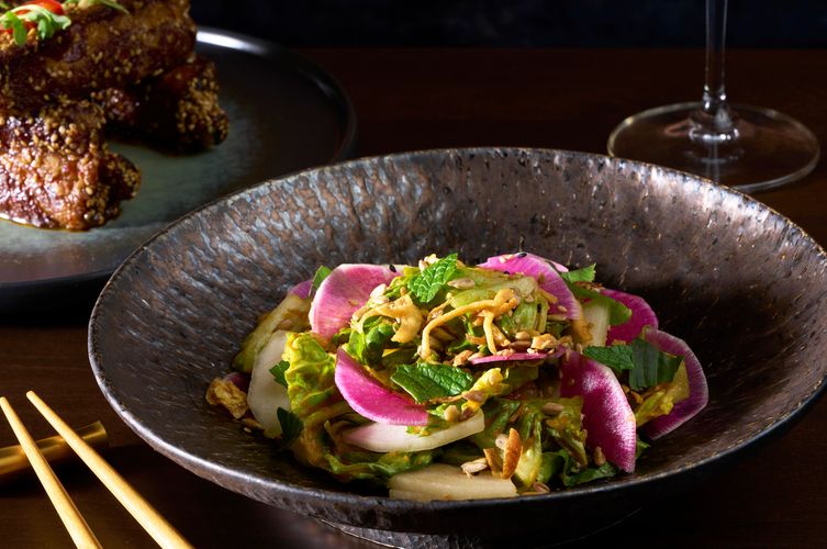 Chopped salad with watermelon radish, mint, and crispy shallots in a dark ceramic bowl at Soy Cowboy in Arlington, by a food and interiors photographer