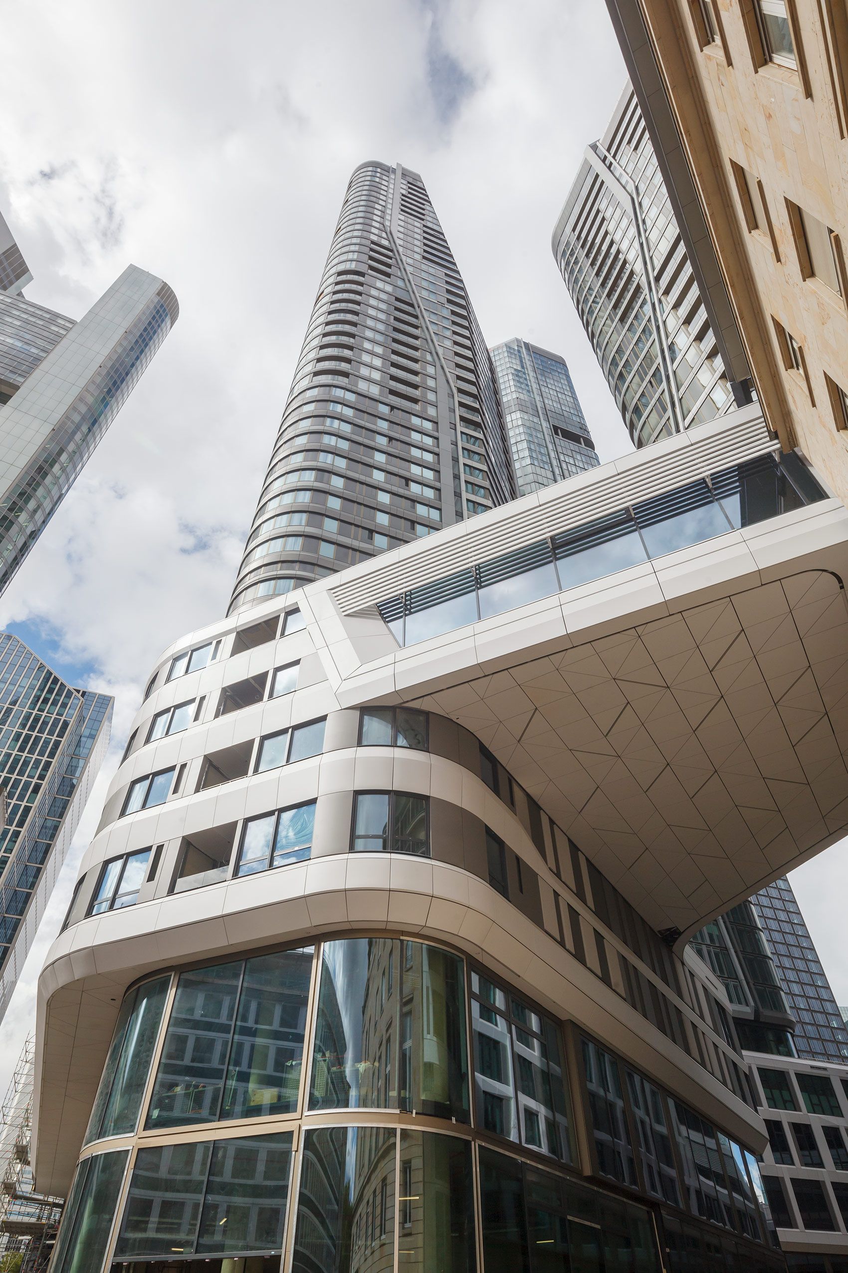 Sehr dynamische Ansicht des Tower T2 vom FOUR Frankfurt mit der eleganten Brücke als Verbindungsteil zum Altbau Look up Tower T2 mit Brücke zum Altbau