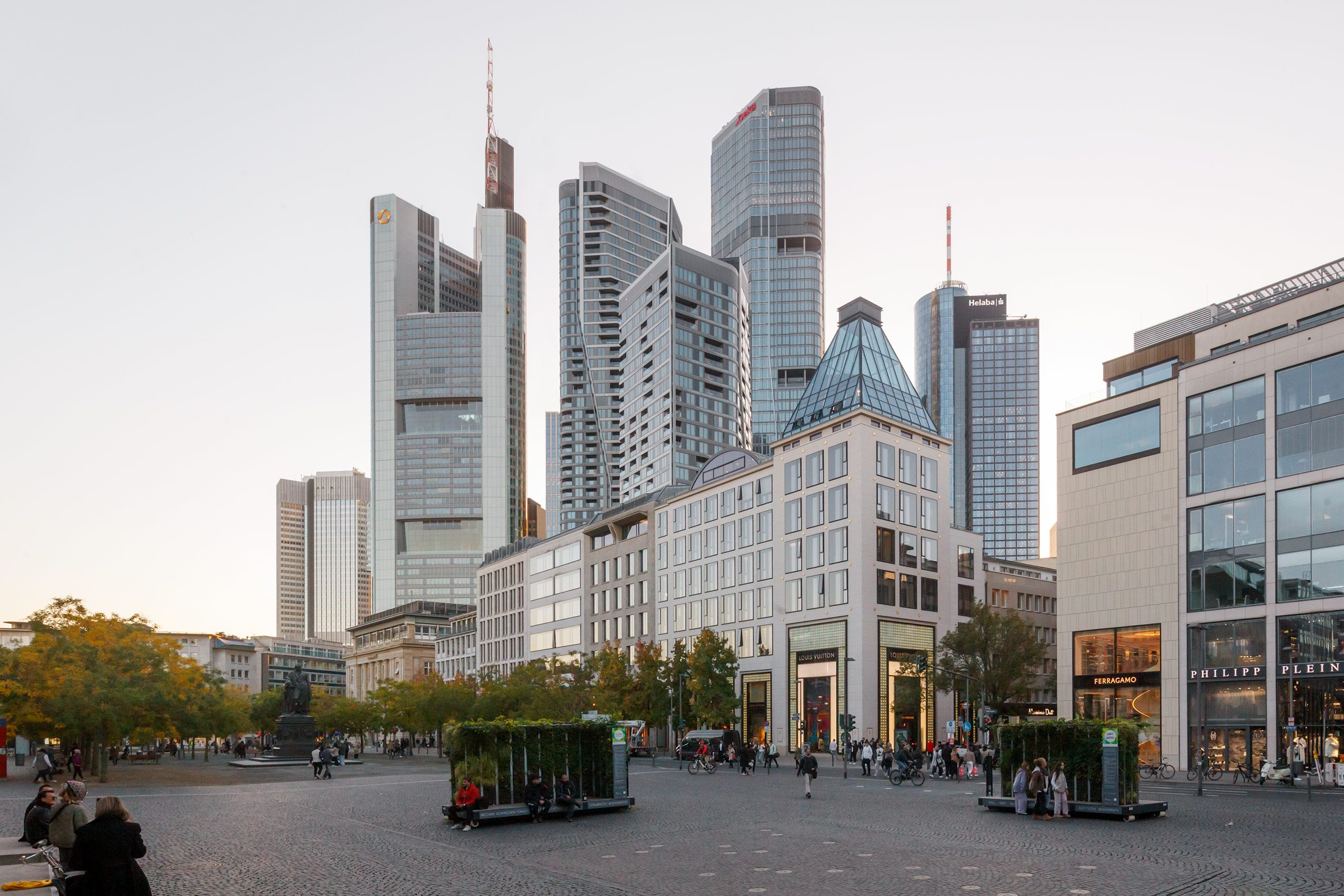 Dämmerungsaufnahme des FOUR Frankfurt mit dem belebtem Goetheplatz im Vordergrund Panorama FOUR Frankfurt mit Goetheplatz