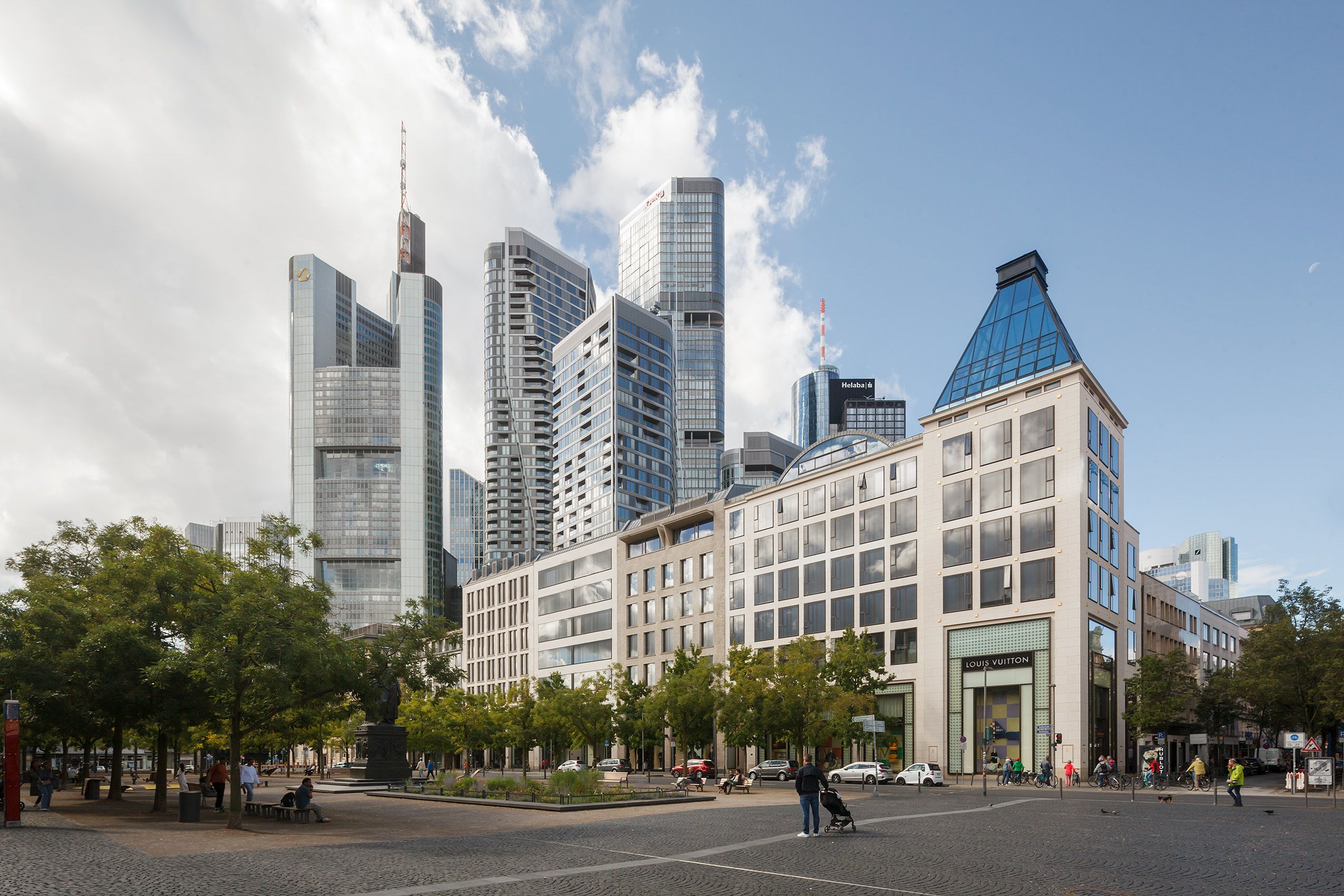 Blick auf FOUR Frankfurt im Zentrum von Frankfurt mit Menschen auf dem belebten Goetheplatz Panorama FOUR Frankfurt