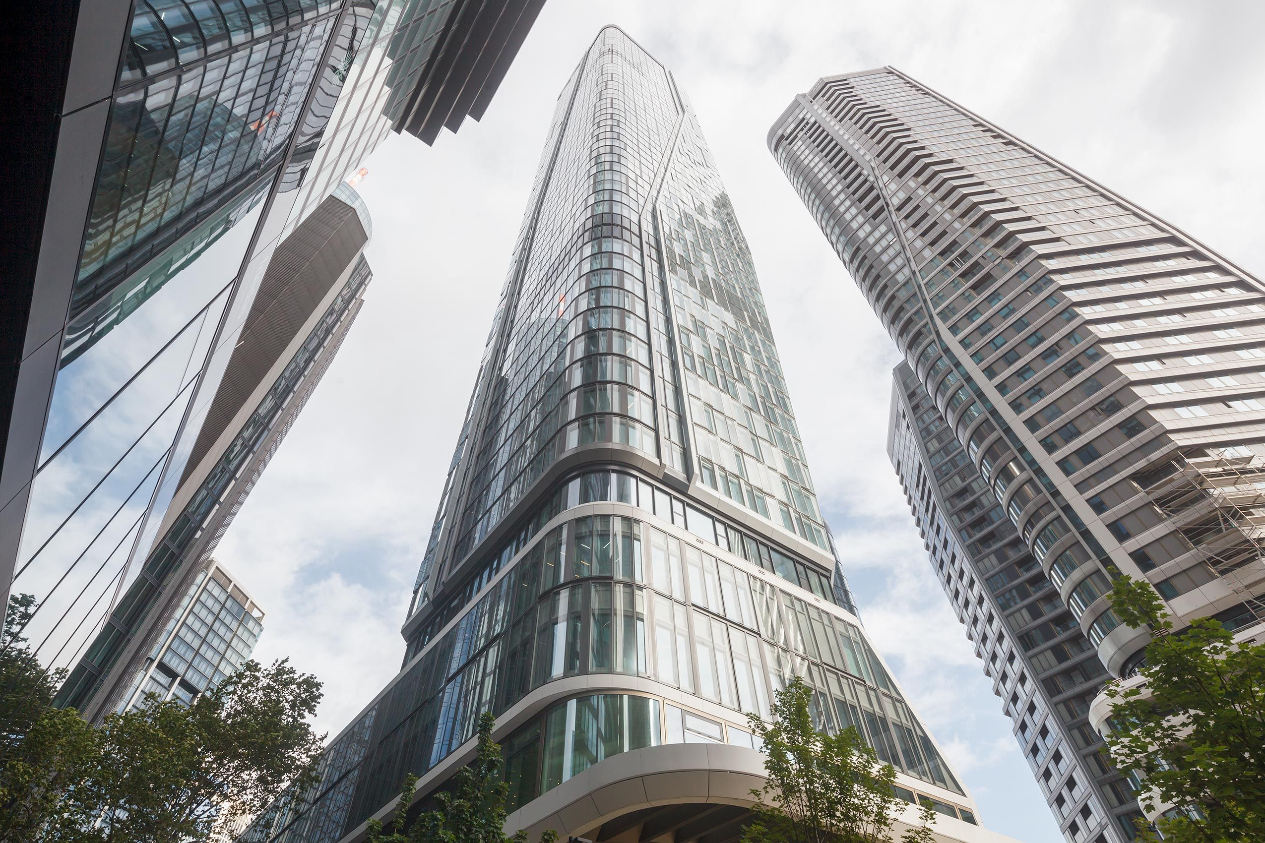 Sehr dynamisch ragen die Tower T1 und T2 vom FOUR Frankfurt in den bleigrauen Frankfurt Himmel Look up Tower T1 und T2