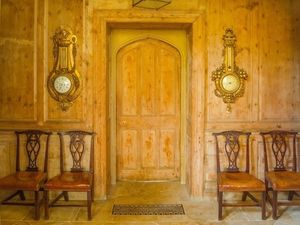 Inquire to acquire official limited edition color fine art prints of a symmetrical private interior room at Stanway House, England by William Curtis Rolf. William Curtis Rolf color photography Stanway House private interior wood panels antique clocks chairs door Gloucestershire England Architectural Details Portfolio