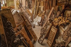 Fine-art color architectural photograph by William Curtis Rolf capturing a dense collection of antique hand-carved wood panels and gilded boiserie under a historic glass roof inside the Féau atelier in Paris, France. Féau Boiserie Archive Paris Antique French Wood Panels Fine Art Print