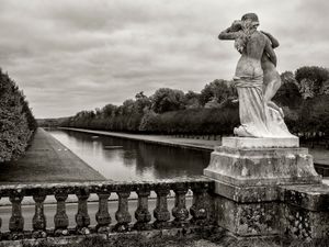 Black and white landscape photograph of a sculpture overlooking the historic Grand Canal at Chateau de Fontainebleau by William Curtis Rolf. Chateau de Fontainebleau French Garden Canal Black and White Print