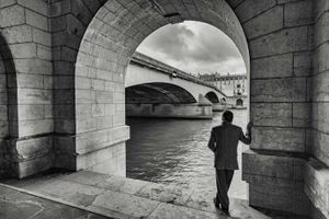 Inquire to acquire official limited edition black and white fine art prints of the Quai des Tuileries in Paris featuring an elegant gentleman, by William Curtis Rolf. William Curtis Rolf black and white photography Quai des Tuileries gentleman right bank Seine river Paris France Architectural Details Portfolio