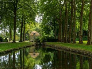 Color landscape photograph of a historic waterside pavilion and canal at Chateau de Courances in France by William Curtis Rolf. Chateau de Courances Maisonette Canal Color Print