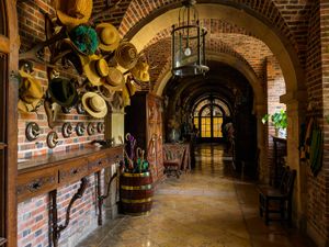 Color architectural photograph of a private arched corridor and hats inside the privately held Château de Courances, France, by William Curtis Rolf. Château de Courances Private Arched Corridor Art Print