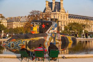 Color photograph of a replica submarine hull emerging from a fountain basin with visitors in the Jardin des Tuileries by William Curtis Rolf. Jardin des Tuileries Paris Submarine Fountain Color Print