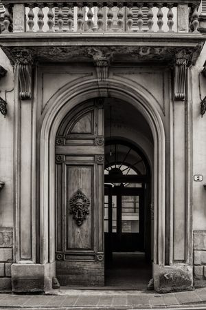 Black and white architectural close up photograph of an ornate arched doorway, courtyard, and detailed balcony in Florence, Italy, by William Curtis Rolf. Florence Italy Renaissance Facade Study 2 Black and White Print