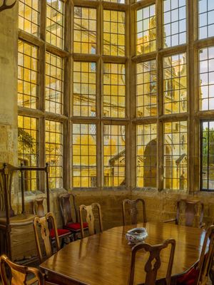 Inquire to acquire official limited edition color fine art prints of the Great Hall full-height oriel window at Stanway House, England by William Curtis Rolf. William Curtis Rolf color photography Stanway House Great Hall oriel window latticed glass Chippendale chairs dining room Gloucestershire England Noble Houses Portfolio