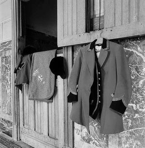 Black‑and‑white study of traditional equestrian attire at the historic stables of Château de Prye in Burgundy, built in 1887 for Marquis Antonin du Bourg de Bozas, photographed by William Curtis Rolf. Black‑and‑white photograph of traditional equestrian attire at the historic stables of Château de Prye in Burgundy, France.