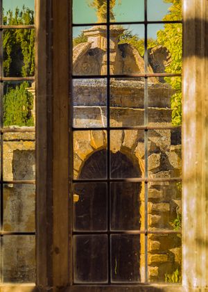 Inquire to acquire official limited edition color fine art prints of the golden Guiting limestone facade framed through an oriel window at Stanway House, England by William Curtis Rolf. William Curtis Rolf color photography Stanway House oriel window Guiting limestone facade Gloucestershire England Architectural Details Portfolio