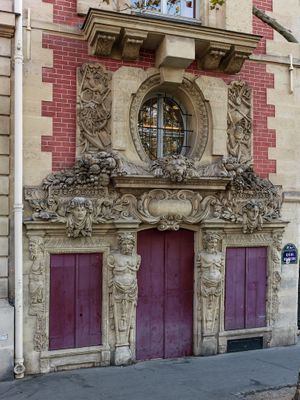 Color architectural close up photograph of the ornate stone facade and bright red entry doors of Hôtel Fieubet École Massillon in Paris by William Curtis Rolf. Hotel Fieubet Ecole Massillon Paris Facade Color Print William Curtis Rolf