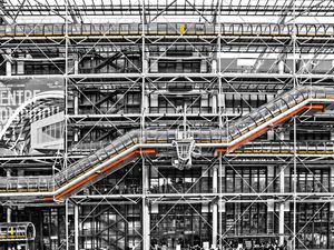 Black‑and‑white photograph of the Centre Pompidou elevator in Paris with selective yellow and orange colors.