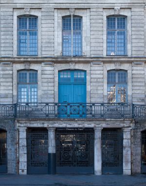 Color architectural photograph of the beige stone Theatre du Nord facade in Lille after sunset, appearing blue as twilight reflects on sky-blue window trim and glass, by William Curtis Rolf. Lille France Theatre du Nord Facade After Sunset Color Print