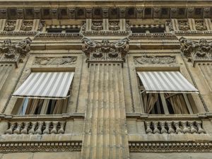 Muted color close up architectural photograph of a stone building facade and striped window covers at the Palais-Royal by William Curtis Rolf. Palais Royal Paris Facade Study 2 Muted Color Print