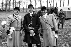 Black and white photograph of three uniformed male participants laughing during a private hunt at Chateau de Champchevrier by William Curtis Rolf