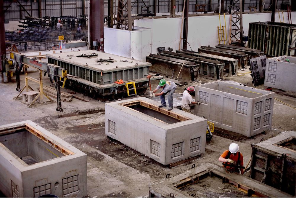 Men in hard hats making precast concrete products  for infrastructure. Utility vaults.
