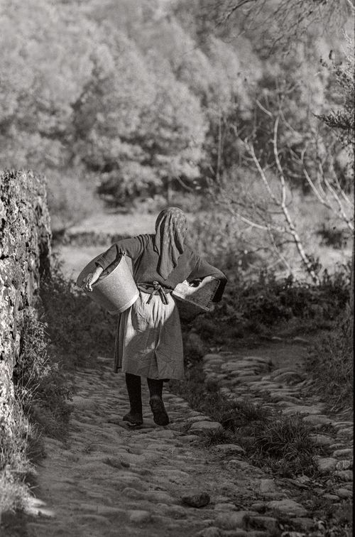 Woman walking with bucket Candalario, Spain 1974