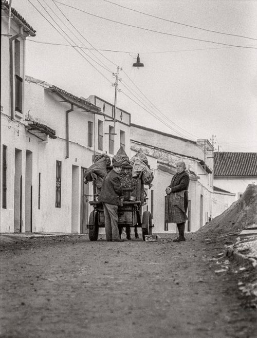 Coal Seller preparing coal for woman south of Badajoz, Spain 1974