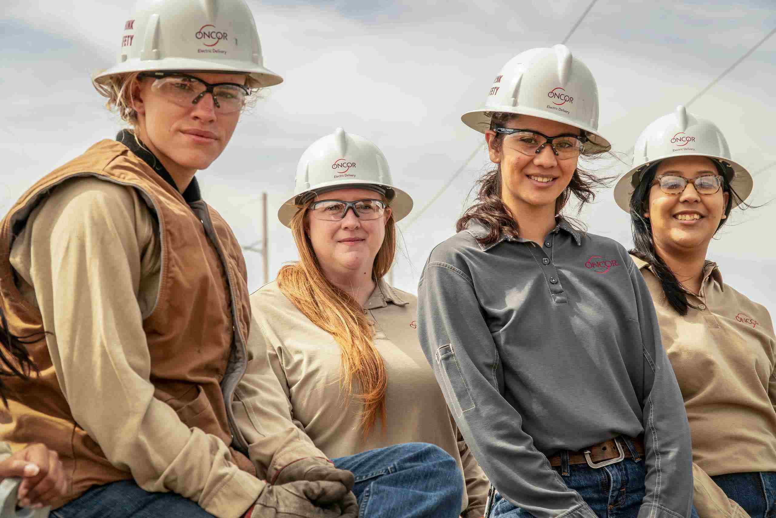Industrial photo of women linemen collaborating on utility work, highlighting teamwork and professional dedication. Women Linemen Working Together - Dallas Professional Headshots