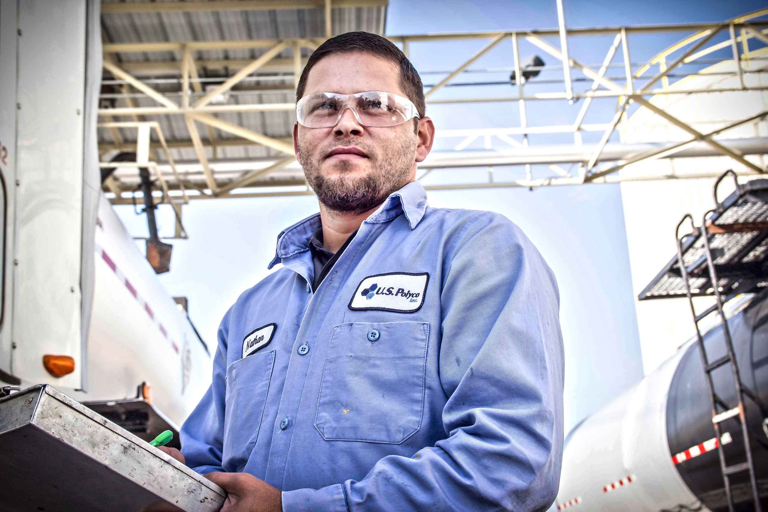 Industrial photo of an asphalt plant employee at work, highlighting infrastructure maintenance and professional dedication in Dallas. Asphalt Plant Employee Working - Dallas Industrial Photography