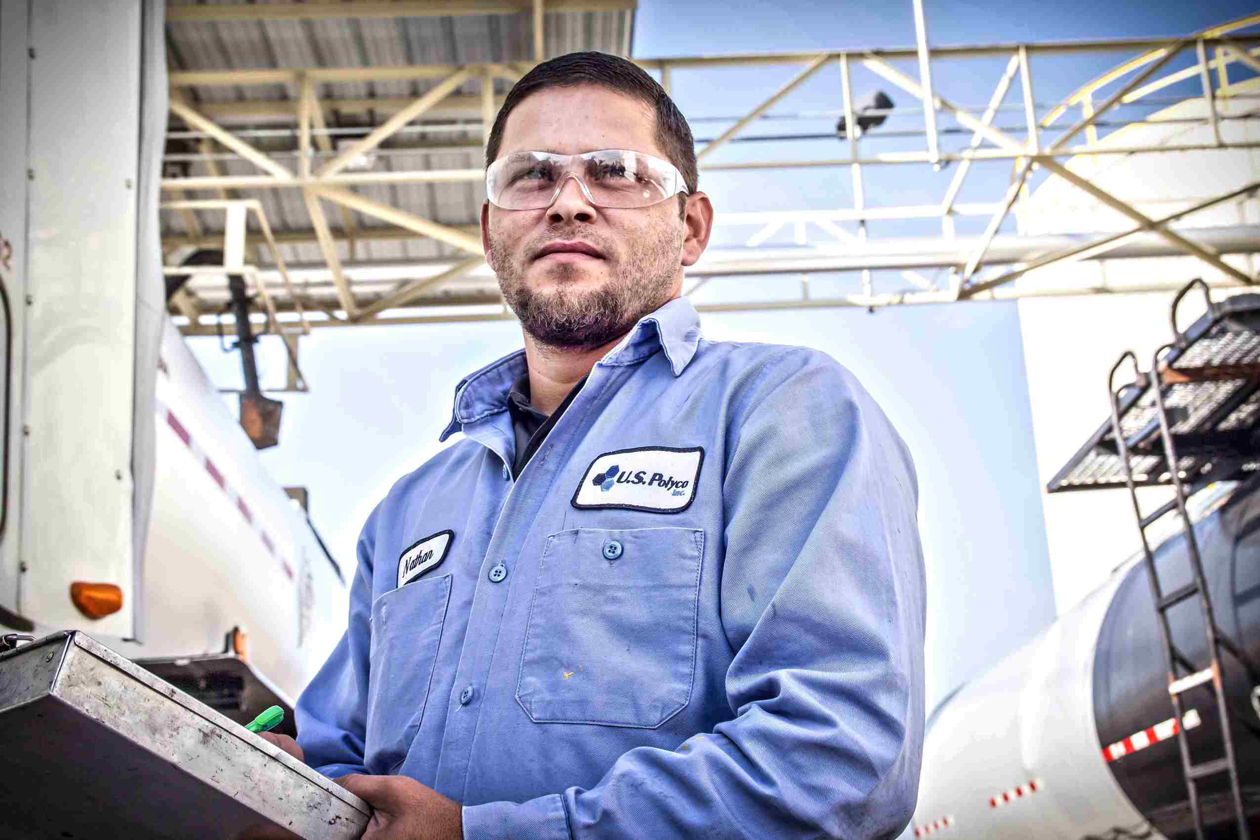 Industrial photo of an asphalt plant employee at work, highlighting infrastructure maintenance and professional dedication in Dallas. Asphalt Plant Employee Working - Dallas Industrial Photography