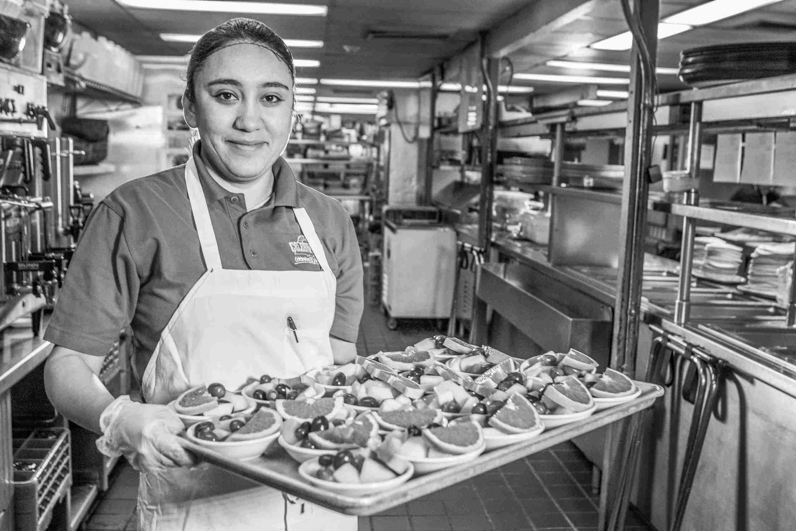 Kitchen employee with deserts .jpg