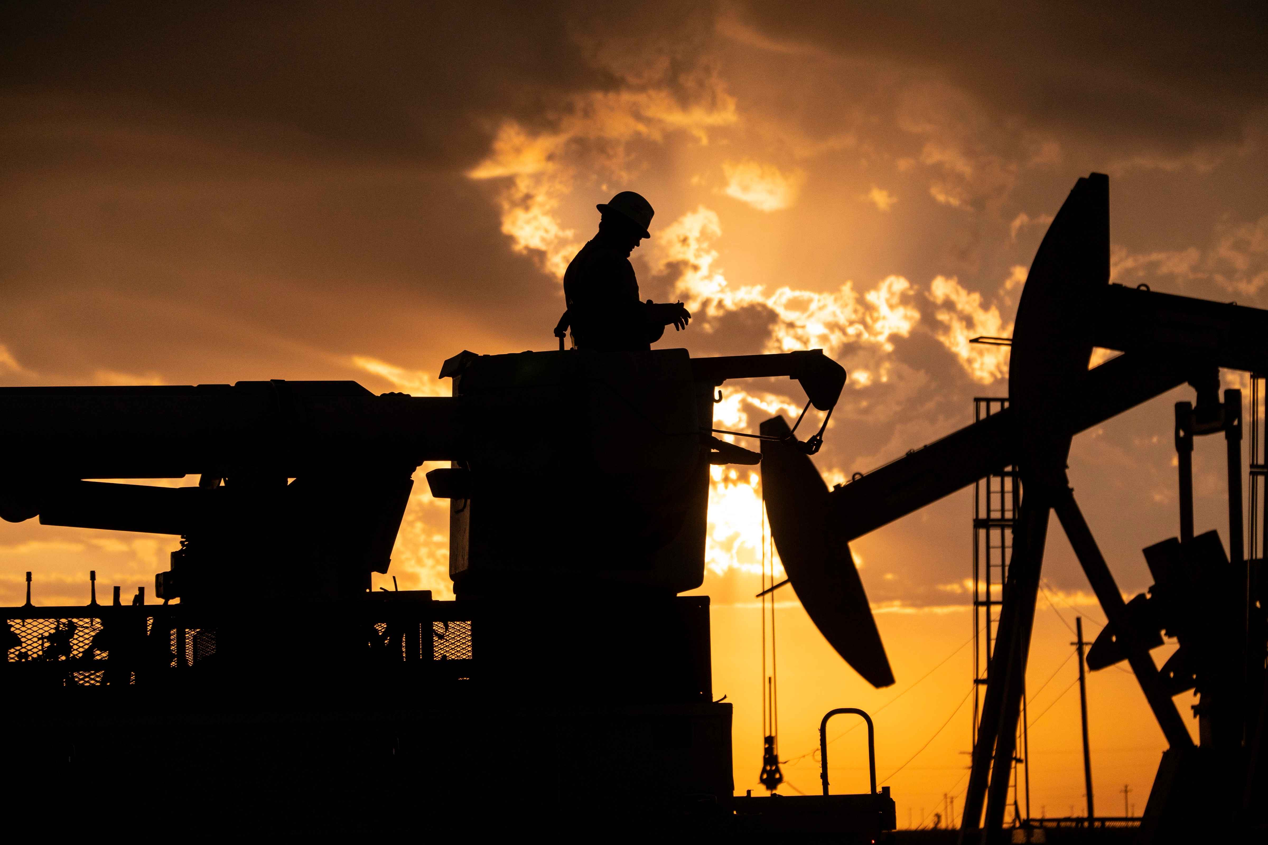 A lineman performing maintenance in an oilfield during sunset, highlighting industrial work and rugged landscapes. Lineman Working in Oilfield at Sunset