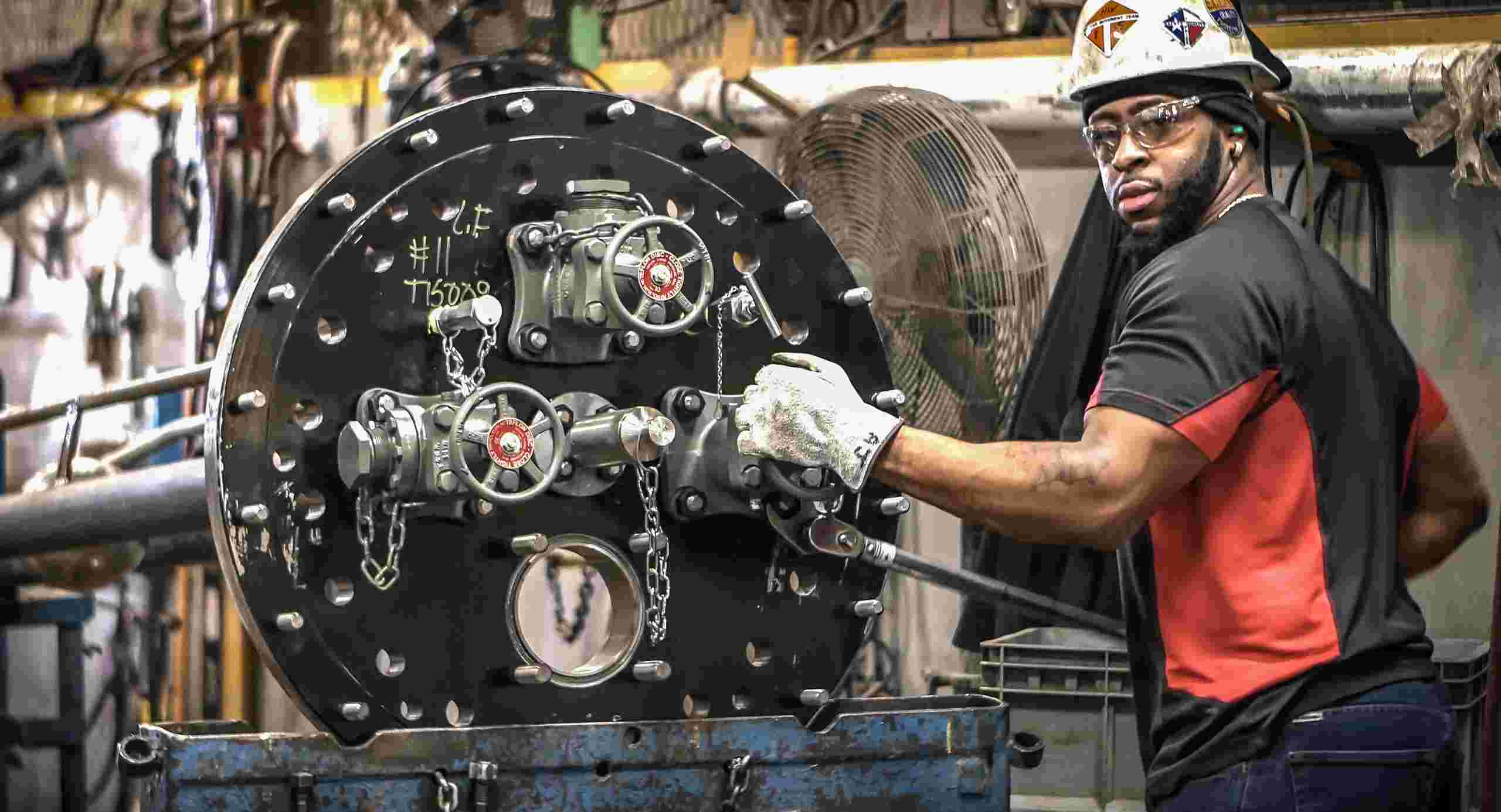 Ensuring Safety: Plant Worker Tightens Pressure Tank Car Fittings